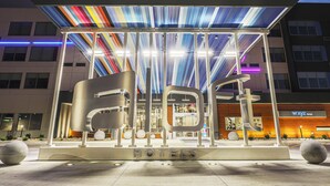 A modern hotel entrance with a distinctive roof structure and a prominent 'HOTELS' sign. - Aloft by Marriott Omaha Aksarben Village (Omaha)
