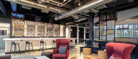 A modern bar area with a bar counter, seating, and a view of the outdoors.