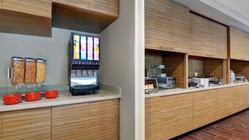 Een moderne keuken met een koffieapparaat, kruidenautomaat en een zelfbedieningsdrankstation.