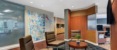 A modern office space with leather chairs, a small table, and a decorative wall.