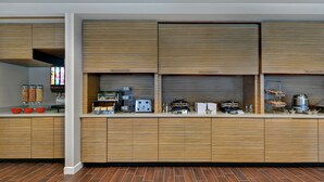 A modern kitchen with wooden cabinets, a built-in oven, and a coffee machine. - TownePlace Suites by Marriott Jacksonville East (Jacksonville)