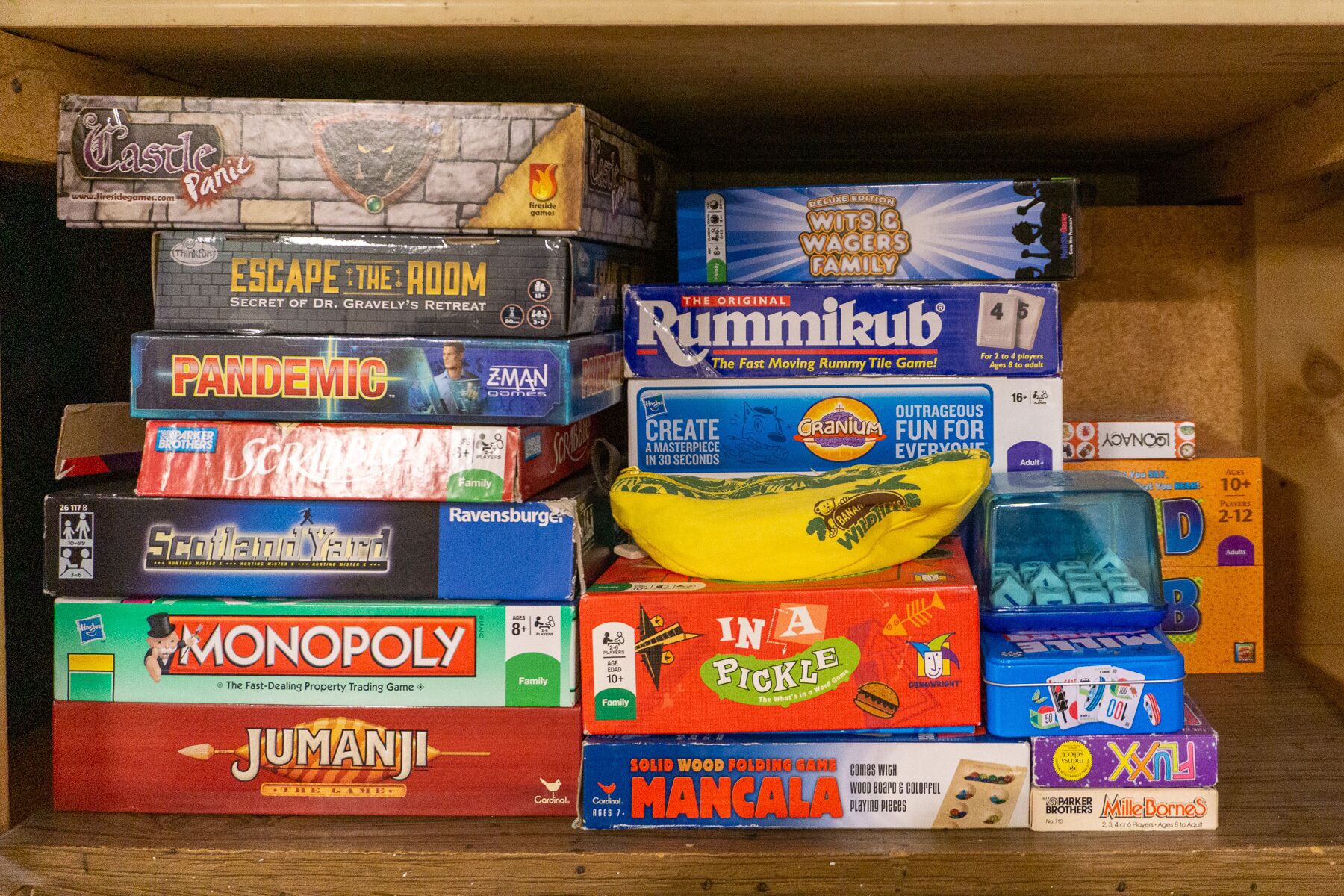 En samling brädspel staplade i en trälåda.