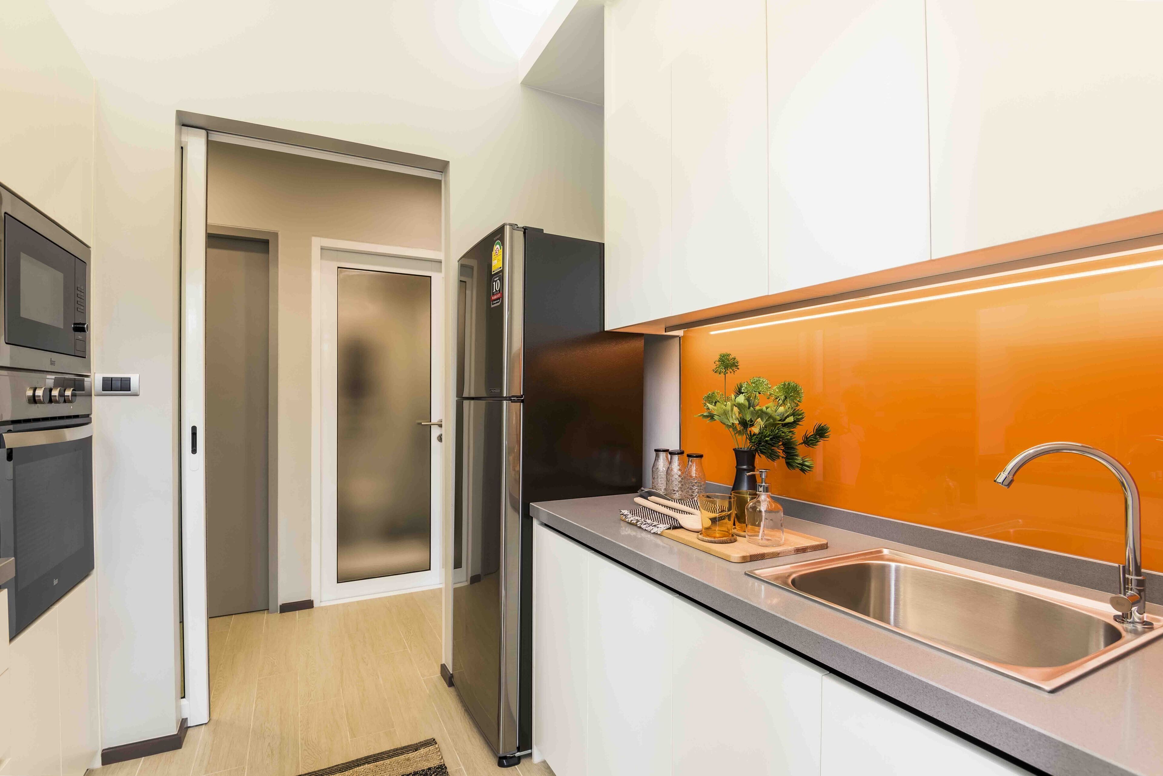 A modern kitchen with stainless steel appliances, a built-in oven, and a sink with a faucet.