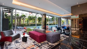 A modern lobby with a pool view, comfortable seating, and a spacious layout.