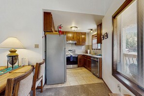 Enjoy meal preparation and dining in this compact kitchen with an oven, refrigerator, and dishwasher.