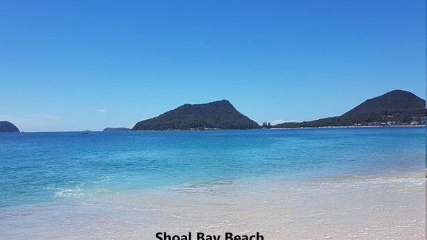 A beach with clear water, distant mountains, and a clear sky. - Willows At The Bay, 111 Horace St - Large House with Aircon, WIFI and Boat Parking (Shoal Bay)