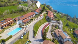 A residential area with a swimming pool, a curved road, and houses with red roofs. - Balcone sul Lago - Apartment with Amazing View Terrace, Tremosine, Italy (Tremosine)