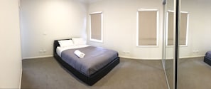 Une chambre à coucher avec un lit, une fenêtre et un miroir.