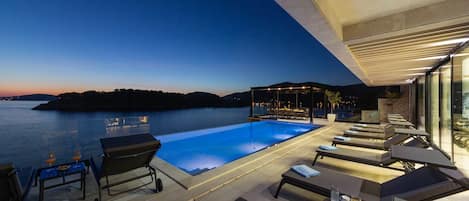 An infinity pool, pool loungers