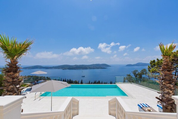 Piscine à débordement, piscine chauffée, chaises longues