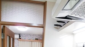 Una habitación compacta con cama, kitchenette pequeña y baño.