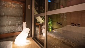 A room with a glass partition, a wooden floor, and a small indoor garden visible through the glass. - A0 Shinjuku Big House (Tokyo)