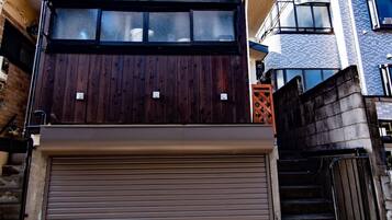 A two-story building with a wooden facade and a brown garage door.