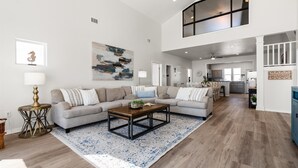 A spacious living room with a large sectional sofa, a wooden coffee table, and a patterned rug. - Private Heated Pool, walkout on the beach! - Island Star (Dauphin Island)