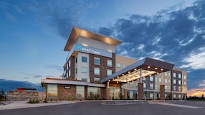Un hotel moderno con techo plano, ventanas amplias y entrada cubierta.