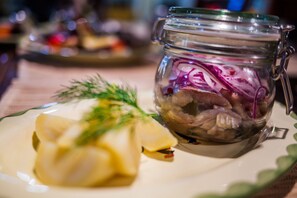 Un plato con comida y un frasco de vegetales encurtidos.