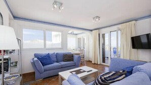 A modern living room with a blue sofa, a coffee table, and a TV mounted on the wall. - Aqua Vista, Golf del Sur (San Miguel de Abona, Golf del Sur)