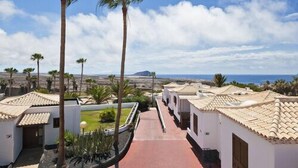 A resort with white buildings and terracotta roofs, a paved walkway, and palm trees. - Aqua Vista, Golf del Sur (San Miguel de Abona, Golf del Sur)
