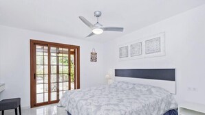 A bedroom with a bed, a ceiling fan, a bench, and a sliding glass door. - Summer House, Golf del Sur (San Miguel de Abona, Golf del Sur)