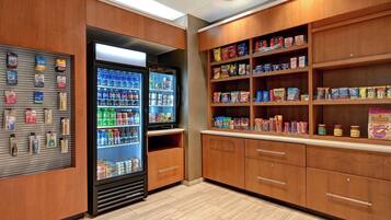 A well-organized pantry with shelves stocked with various food items and a refrigerator filled with beverages.