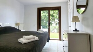 A bedroom with a bed, a desk, a lamp, a mirror, and a sliding glass door to the outside. - Ocean Villa, Golf del Sur (San Miguel de Abona, Golf del Sur)
