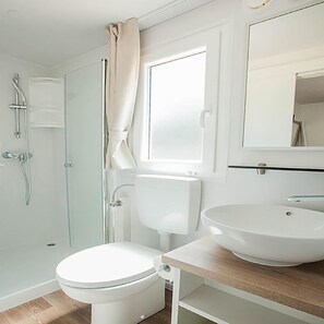 A bathroom with a toilet, sink, and shower.