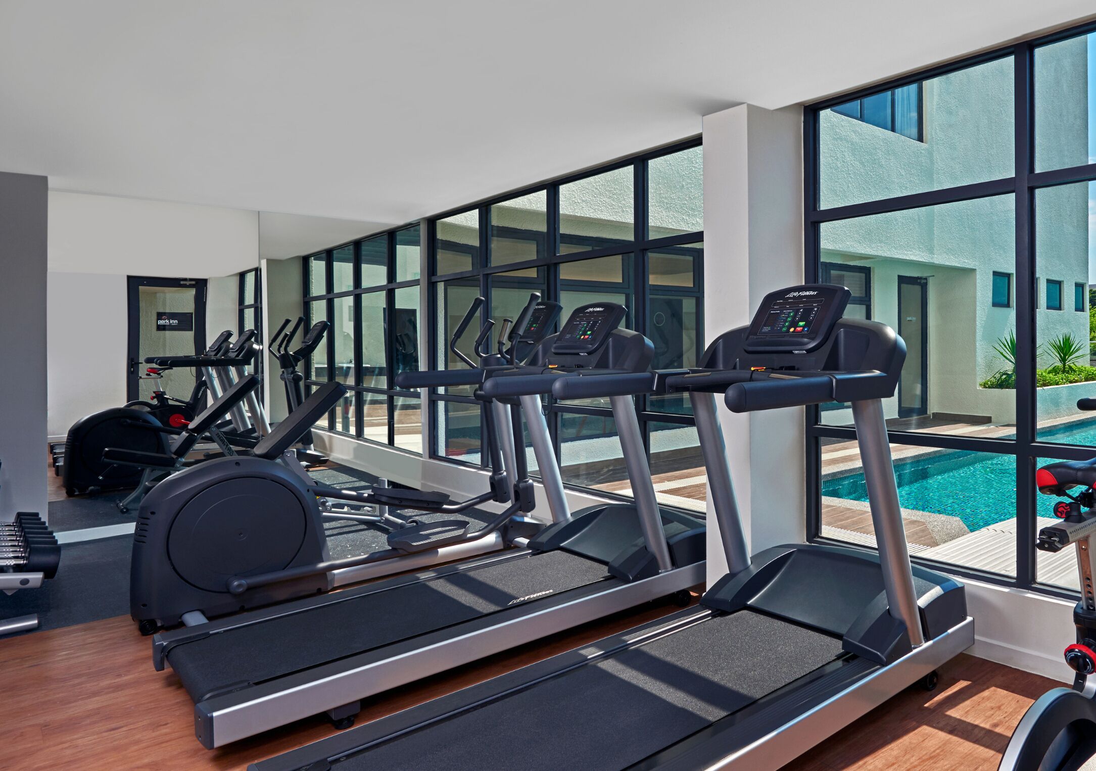 A gym with treadmills, elliptical machines, and a rowing machine.