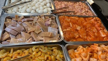 A buffet with various food items including meats, seafood, and other dishes.