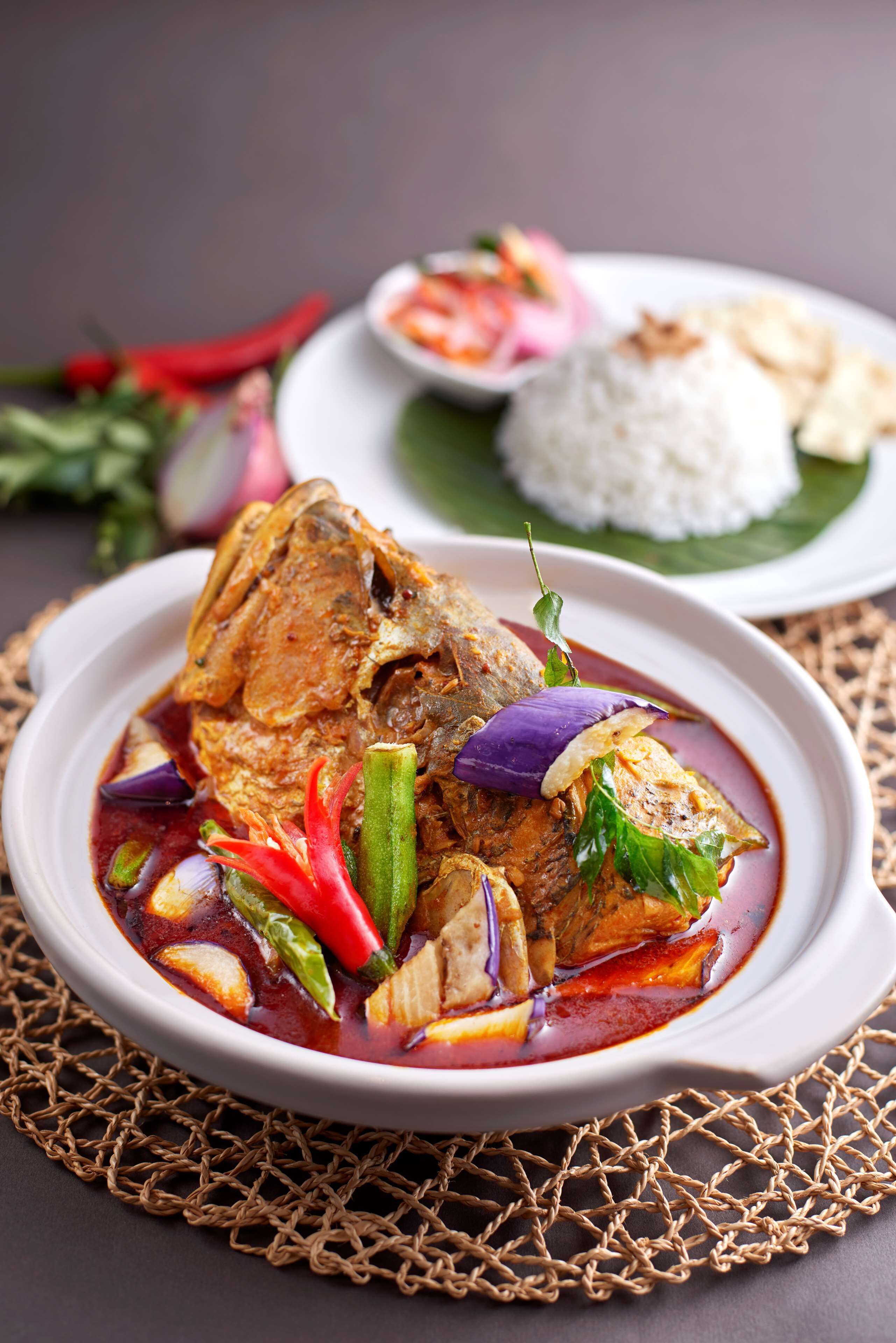 Un plat de curry de poisson, accompagné de légumes et de riz.