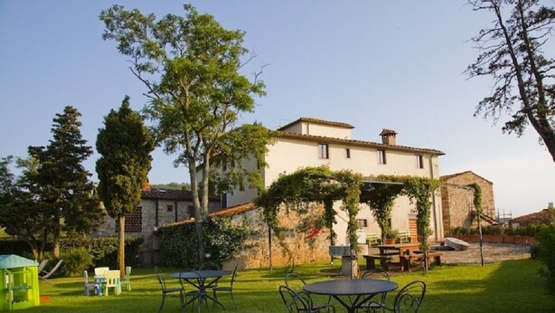A villa with a patio area featuring outdoor seating and a stone wall.