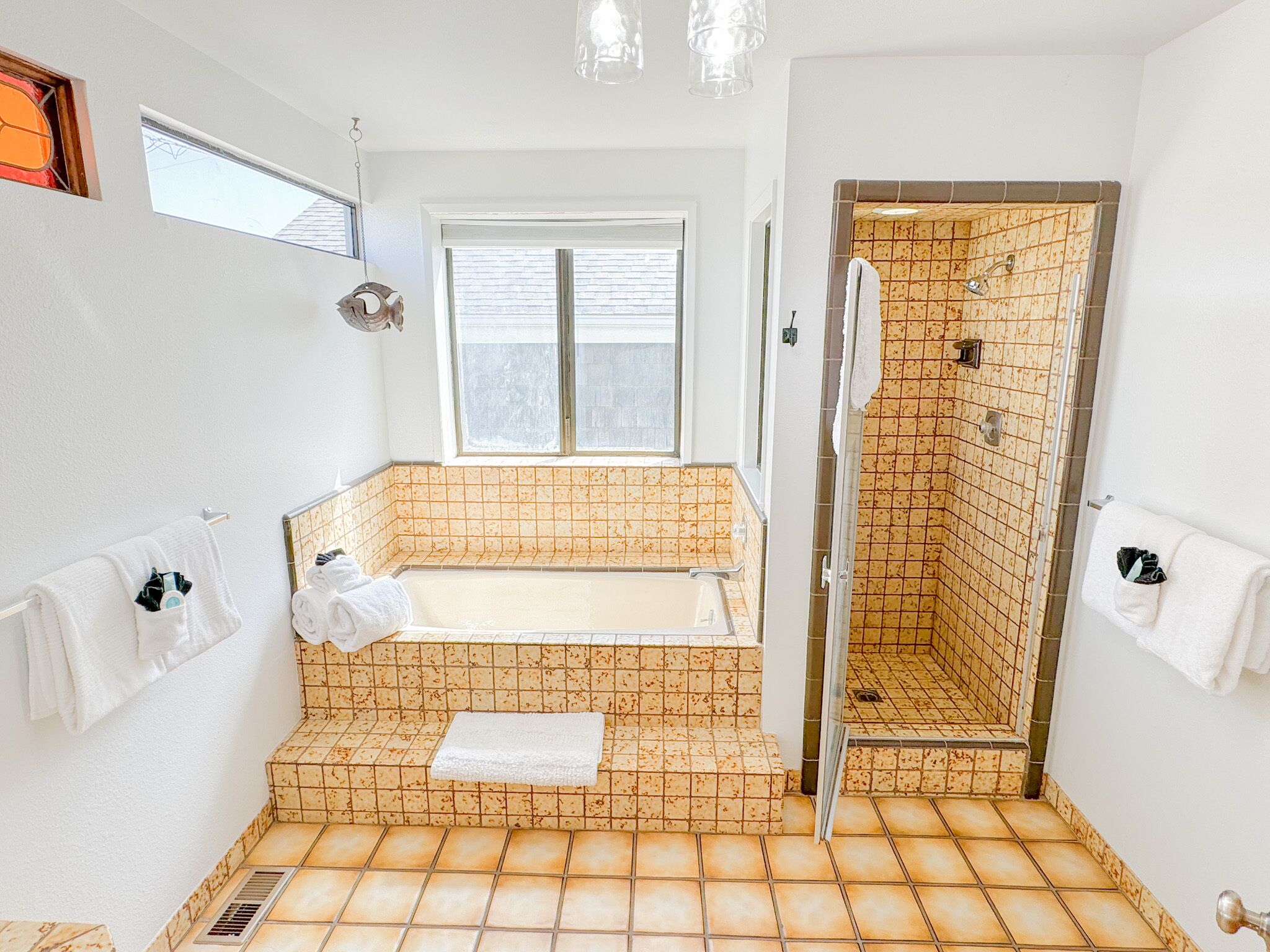 Une salle de bain avec une baignoire, une douche et une fenêtre.