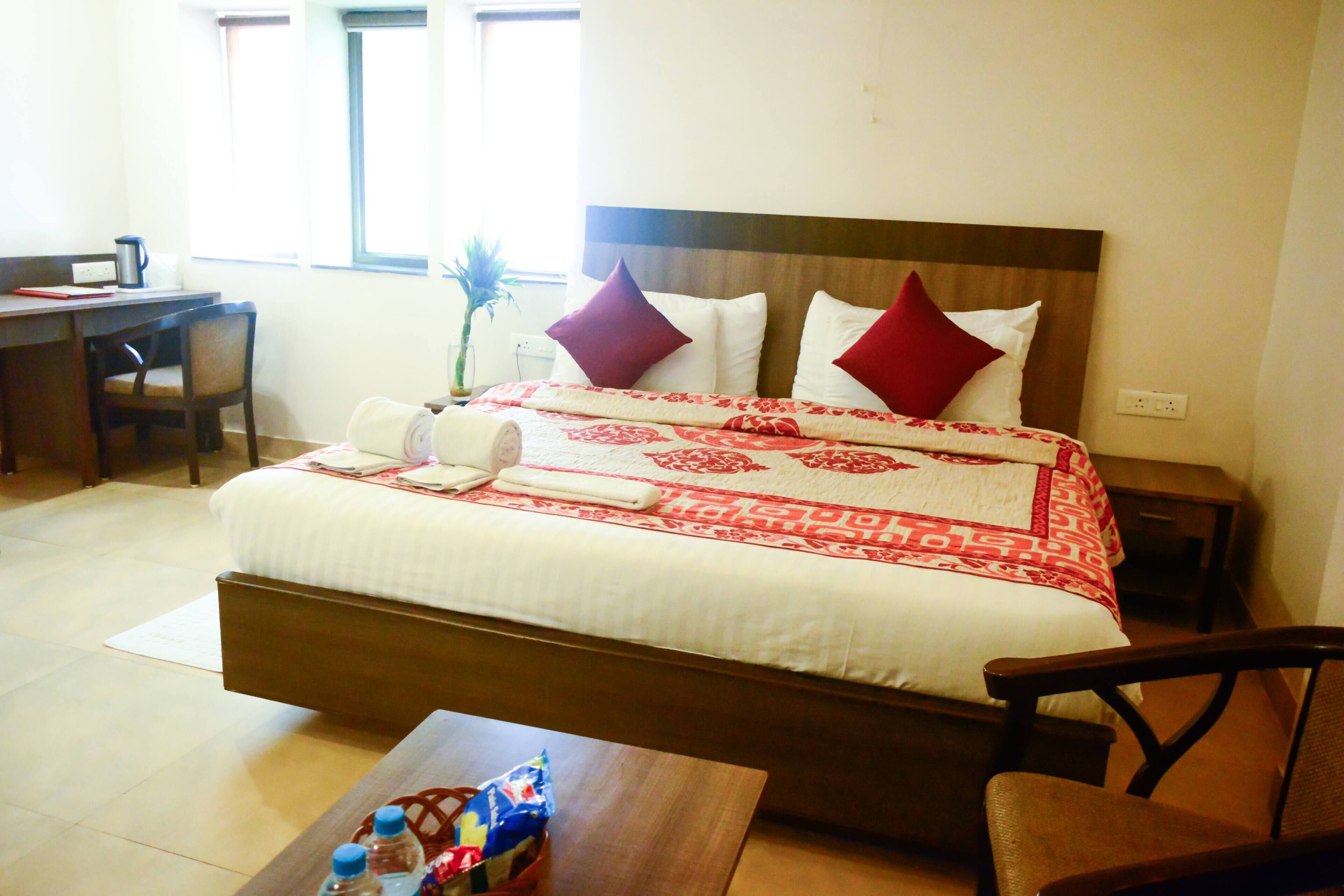 Une chambre d’hôtel avec un grand lit, un bureau et une chaise.