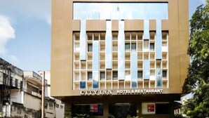 Un moderno edificio de hotel con entrada central y numerosas ventanas.