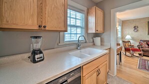 A kitchen with wooden cabinets, a double sink, a blender, and a dishwasher. - Well-Equipped Cody Cottage: 2 Mi to Cody Rodeo! (Cody)
