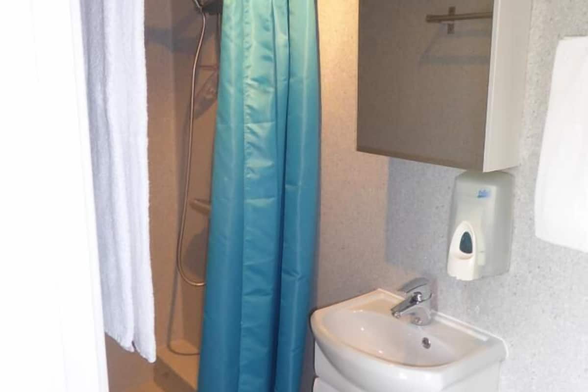 basic twin room | bathroom | shower, hair dryer, towels, soap