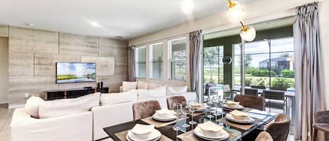 Un comedor moderno con una gran mesa dispuesta para seis personas, rodeada de asientos cómodos.