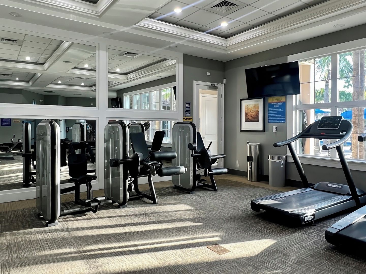 A gym with cardio equipment, weight machines, and a treadmill.