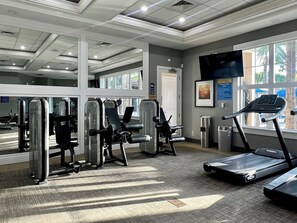 A gym with cardio equipment, weight machines, and a treadmill.