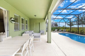 Une terrasse couverte avec une piscine, des sièges d’extérieur et une vue sur le paysage.