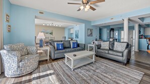 A spacious living room with a ceiling fan, two sofas, a coffee table, and a rug.