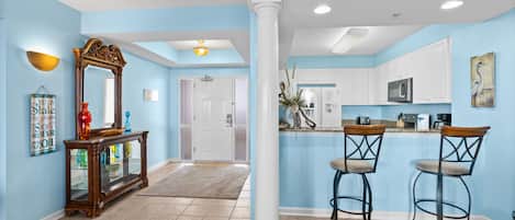 A modern kitchen with white cabinets, a microwave, and a coffee maker.