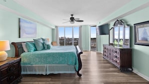 A bedroom with a bed, dresser, and a ceiling fan.