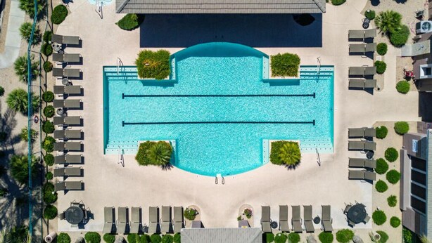 An aerial view of a hotel with a large central swimming pool, sun loungers, and a covered area. - 2BR Modern Scottsdale Condo W/  Heated Pool, Hot Tub, Kg Bed, Gym, & Fast WiFi (Scottsdale)