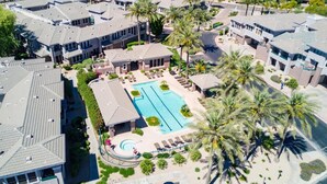 A residential area with multiple houses, a swimming pool, and palm trees. - 2BR Modern Scottsdale Condo W/  Heated Pool, Hot Tub, Kg Bed, Gym, & Fast WiFi (Scottsdale)