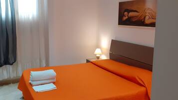 A hotel room with a bed, a nightstand with a lamp, and a painting on the wall.