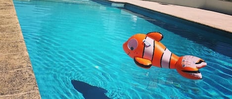 Una piscina al aire libre de temporada, sombrillas