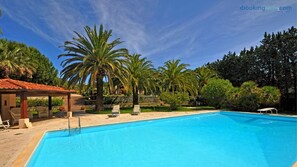 Piscine extérieure en saison, parasols, chaises longues