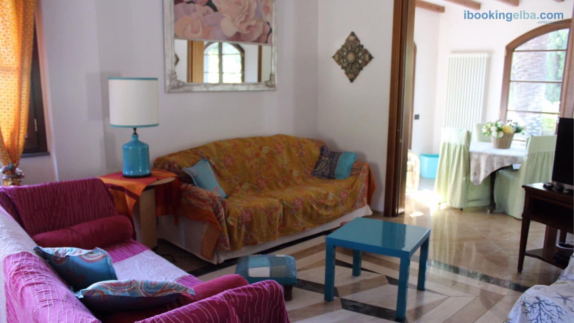 A living room with a sofa, a coffee table, a lamp, and a television.