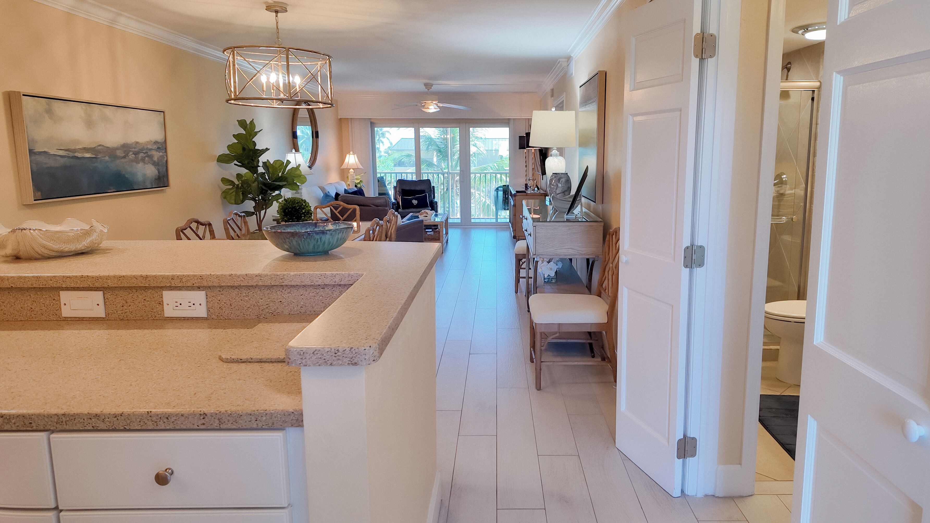 A spacious kitchen with a central island, a dining area with a view, and a modern bathroom.
