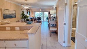 A spacious kitchen with a central island, a dining area with a view, and a modern bathroom.